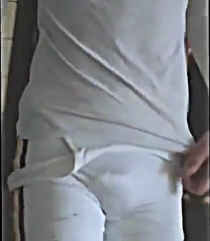 fat cock wrestler walks around meet in white singlet