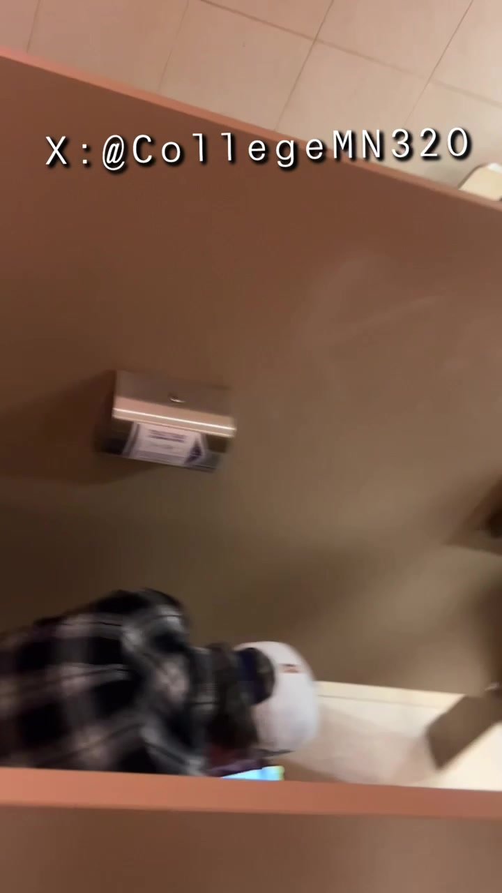 Guy on phone in restroom.