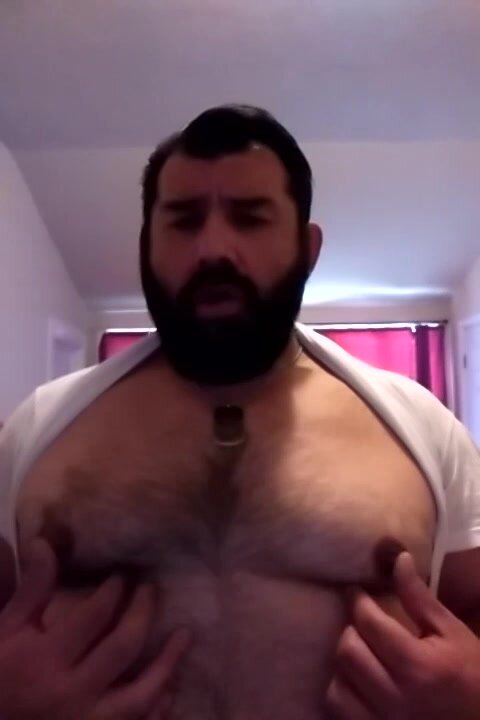Handsome bearded stud plays with his tits