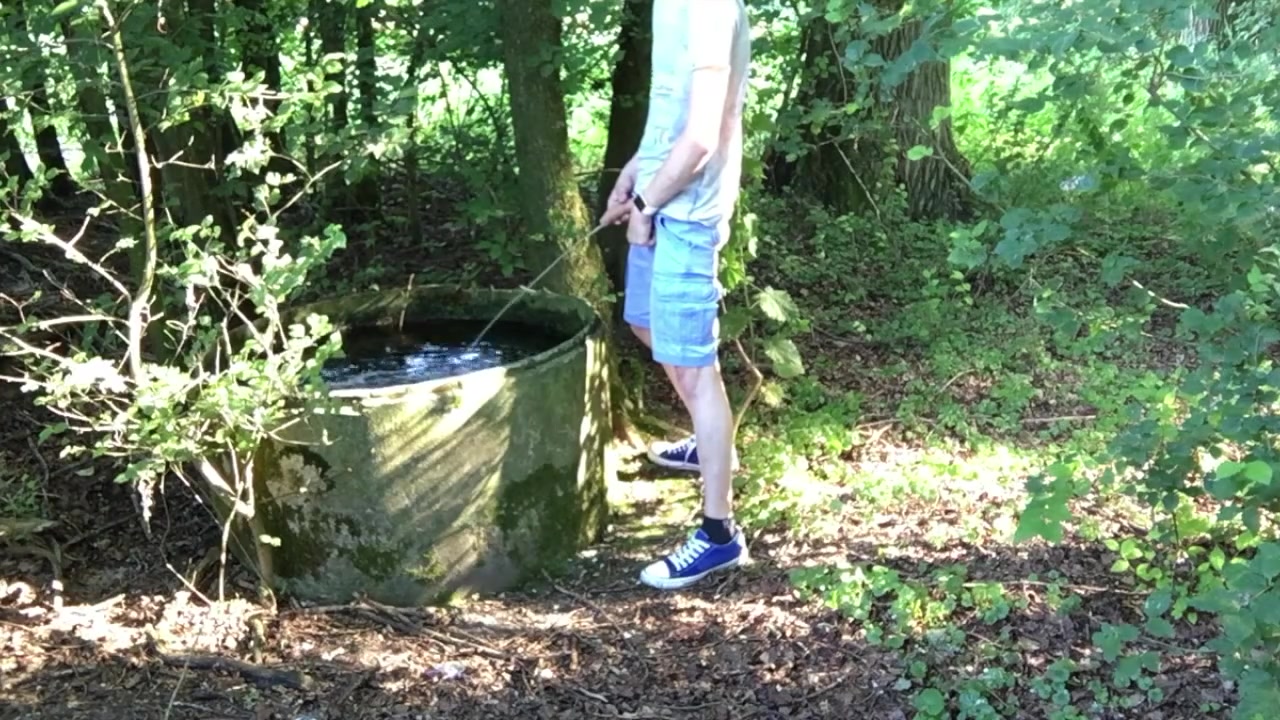 Boy pissing into water tank