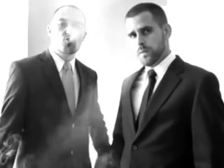 two men in business outfit smoke and kiss