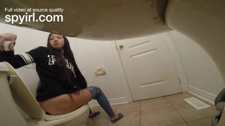 Asian girl changes toilet paper roll