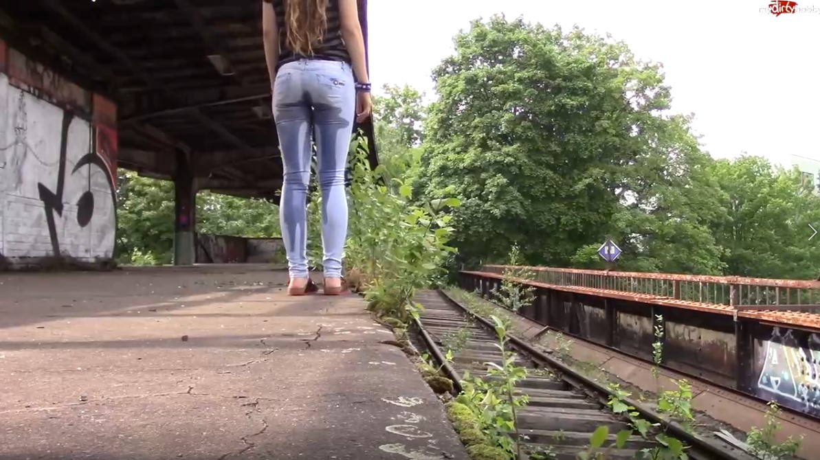 Girl wetting her jeans at an abandoned train station