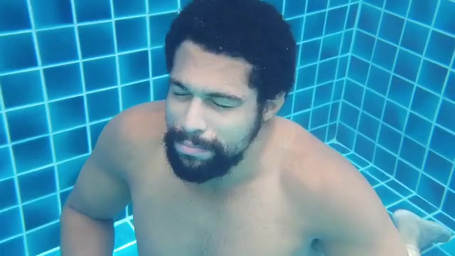 Beefy guy breatholding barefaced underwater