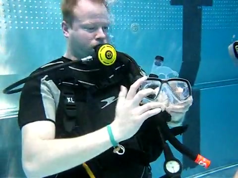 Beefy scubadivers removing mask underwater