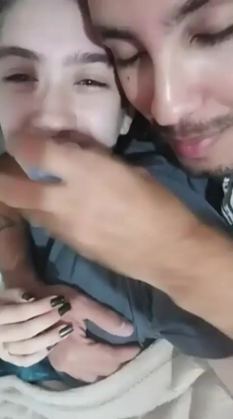 Girl with her boyfriend in bed playing with binkie