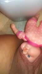 Woman sticks babydoll head in her pussy