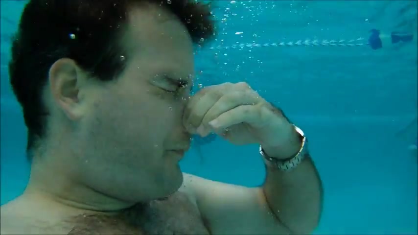 Hairy guy blows air rings underwater