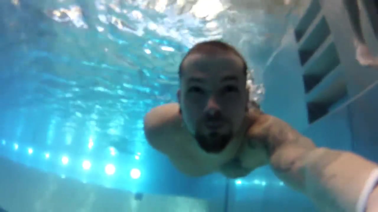 Barefaced bearded guy underwater in pool