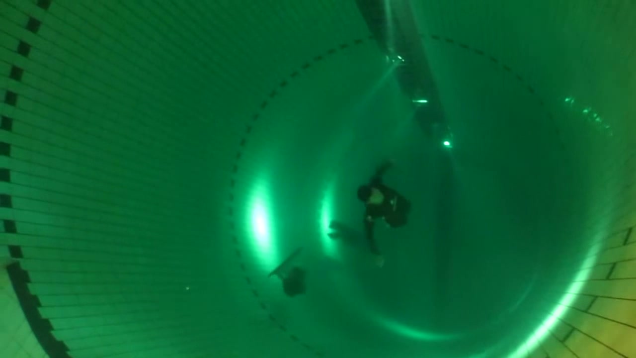Diving deep underwater barefaced in speedo