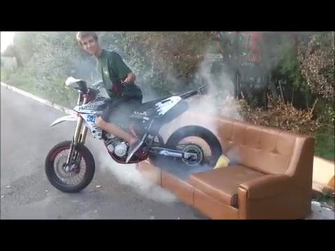 Crazy guy destroys sofa with burning tire