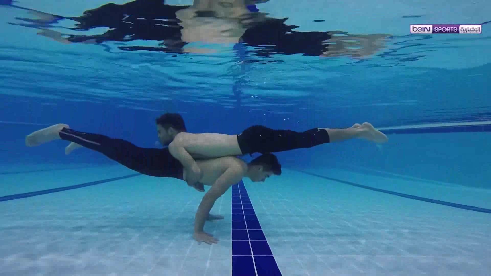 Barefaced arabs exercising underwater in pool, extended