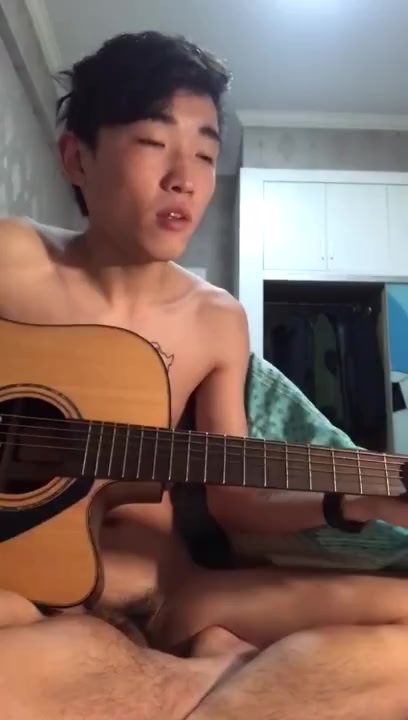 Naked asian man play guitar