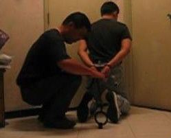 Officer locking  handcuffs and shackles onto prisoner