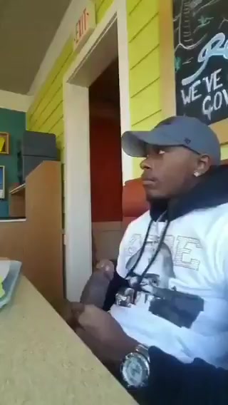 Lad stroking his cock in busy cafe