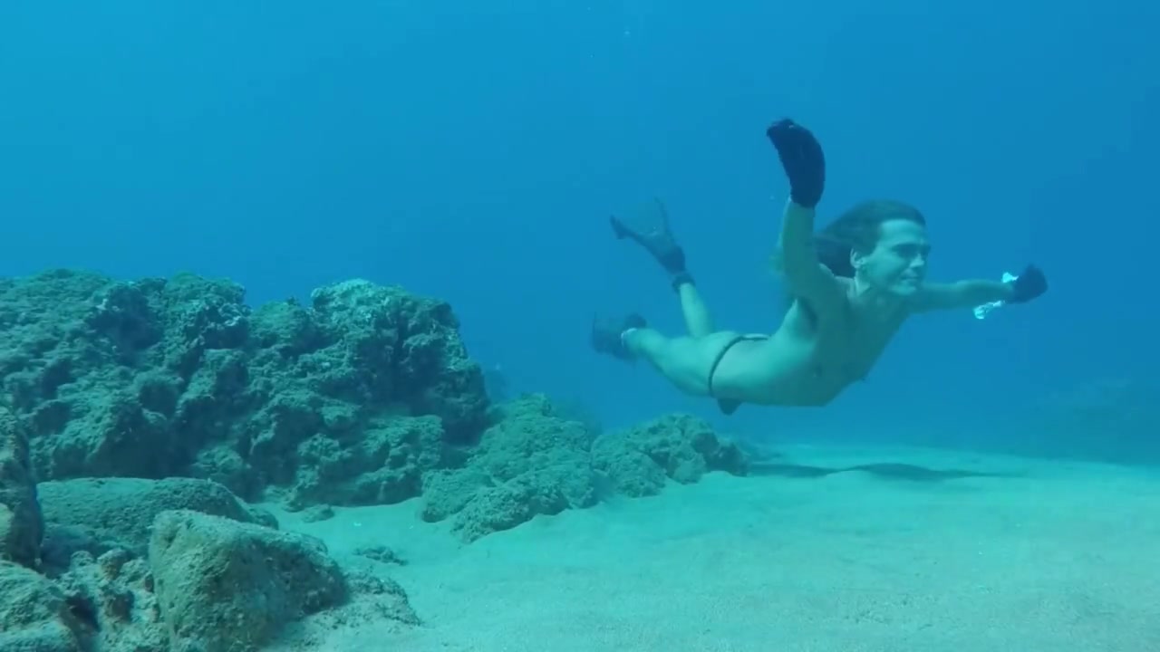 Freediver breatholding underwater in thong