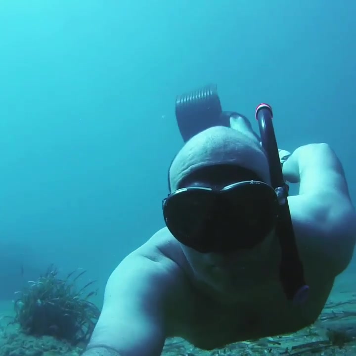 Bald freediver breatholding underwater