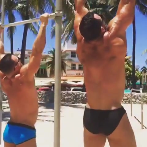 Bodybuilders in speedos at the beach