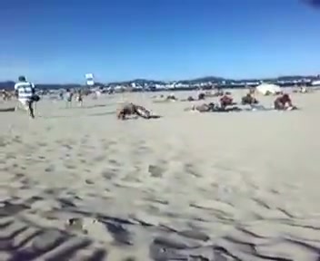 Naked guy doing back-rolls on a beach