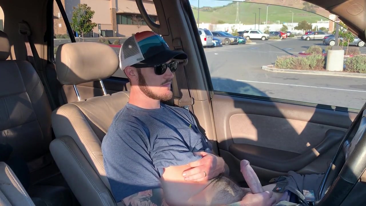 Stroking his cock in his car in busy parking lot. 