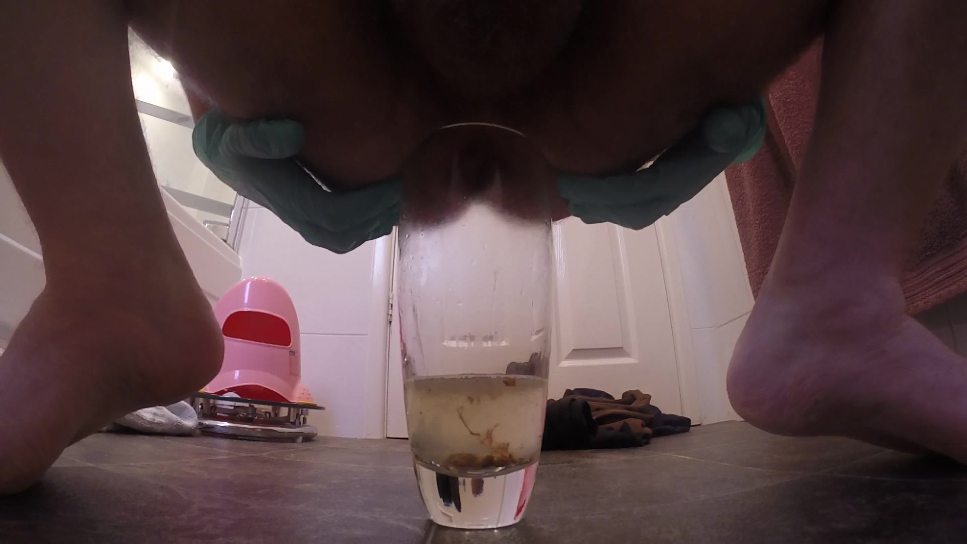 Doing an enema into a glass cup