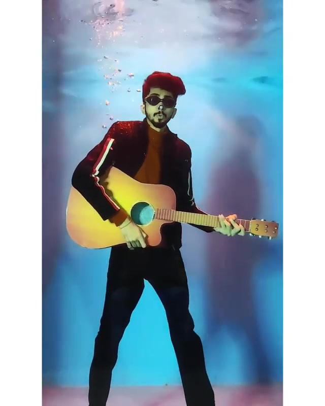 Indian guy playing guitar underwater