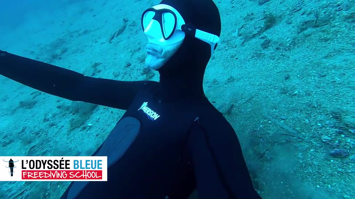 Cutie freediving deep underwater in tight wetsuit