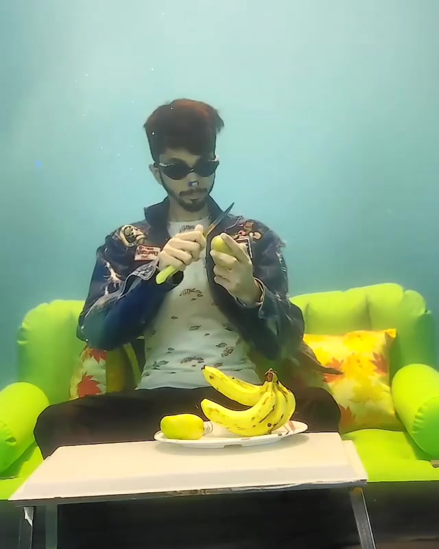 Breatholding indian eating mango underwater