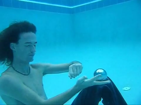 Long haired guy breatholding barefaced underwater