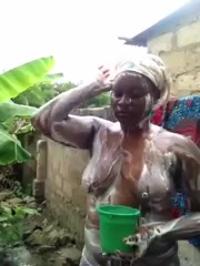 African busty girl takes a shower outside