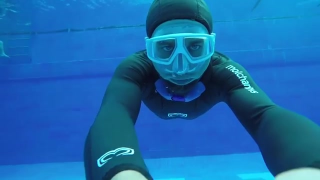 Swimming underwater in tight wetsuit
