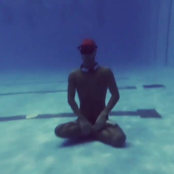 Underwater breatholding yoga in speedos