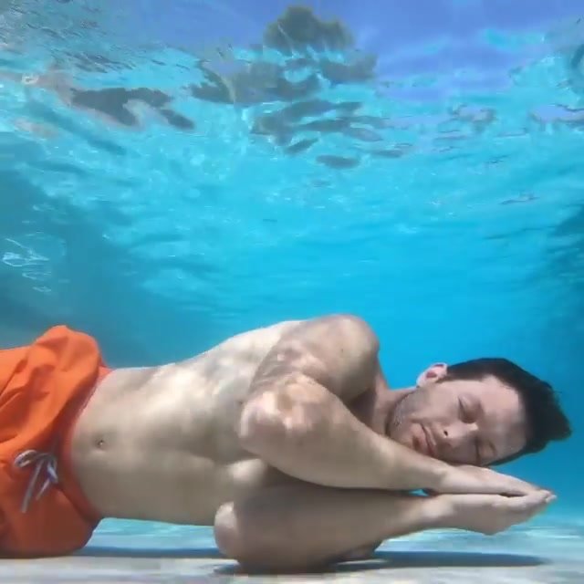 Hunk sleeping underwater in pool