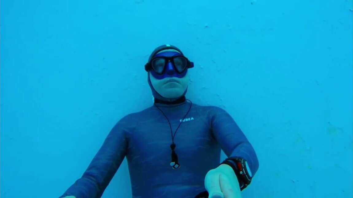 Underwater breathold in blue wetsuit