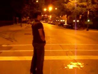 A guy pissing on a street.