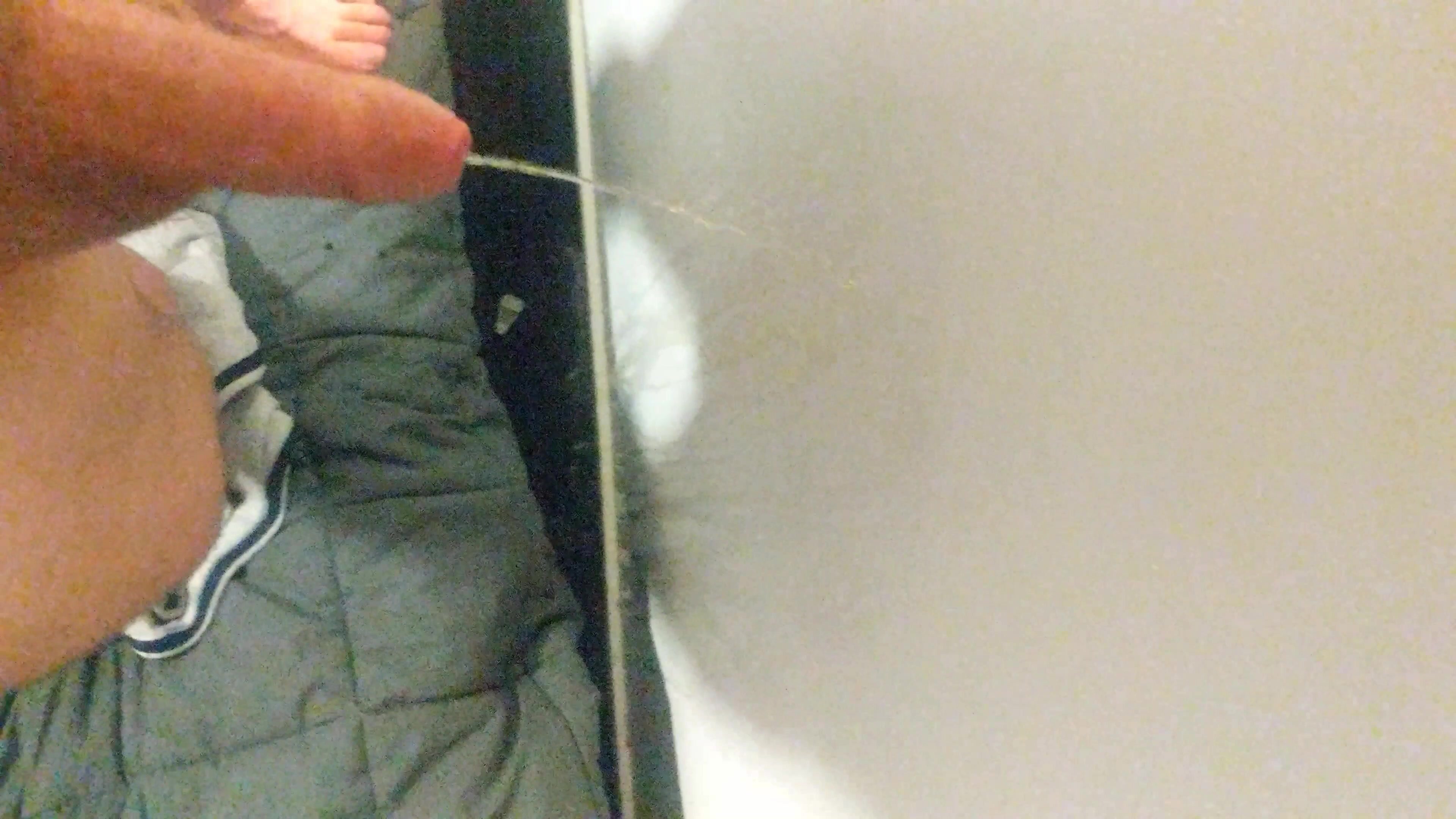 Two men piss in hotel room behind bed and against wall