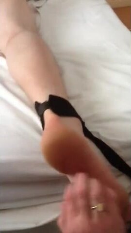 Tickle bare feet on hotel bed