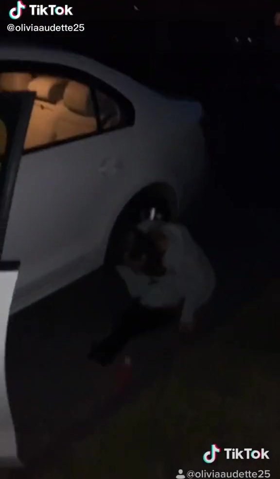 ... girl peeing next to a car on the road