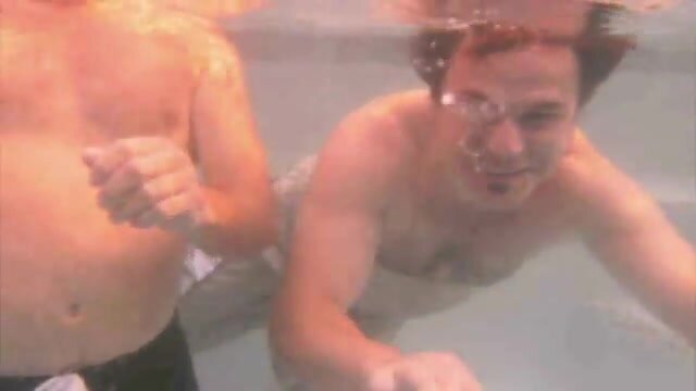 Buddies breatholding barefaced underwater in pool