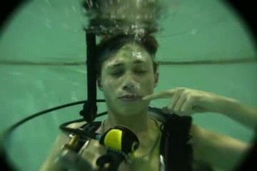 Scubadiver exhaling his air barefaced underwater in pool