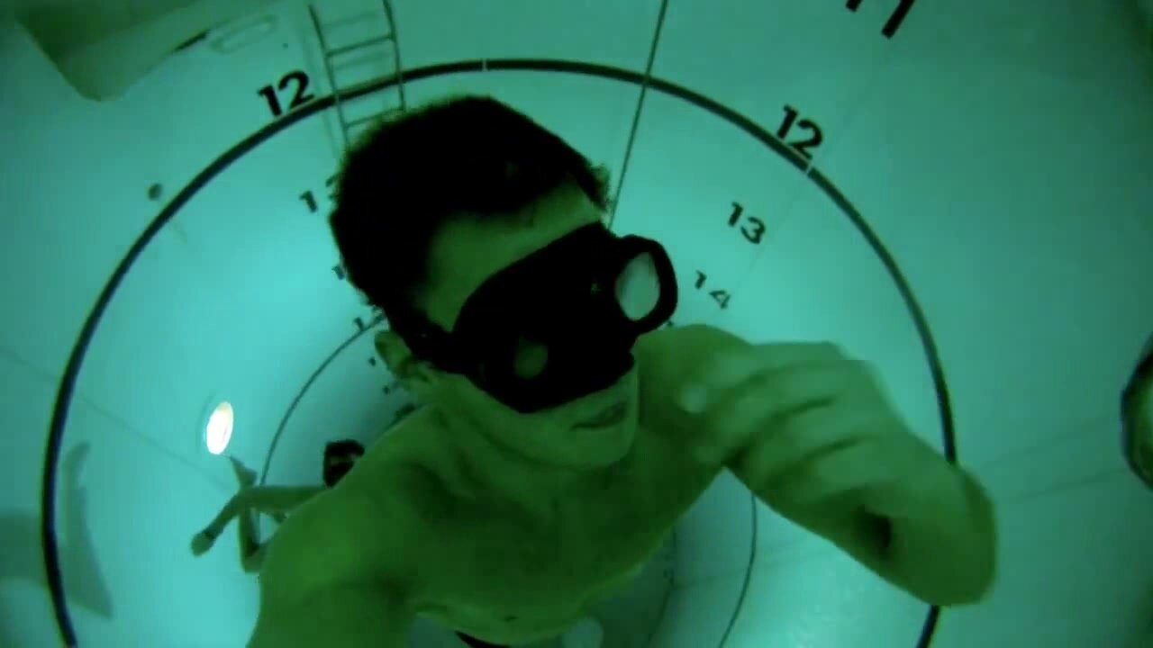 Buddies breatholding underwater in tank
