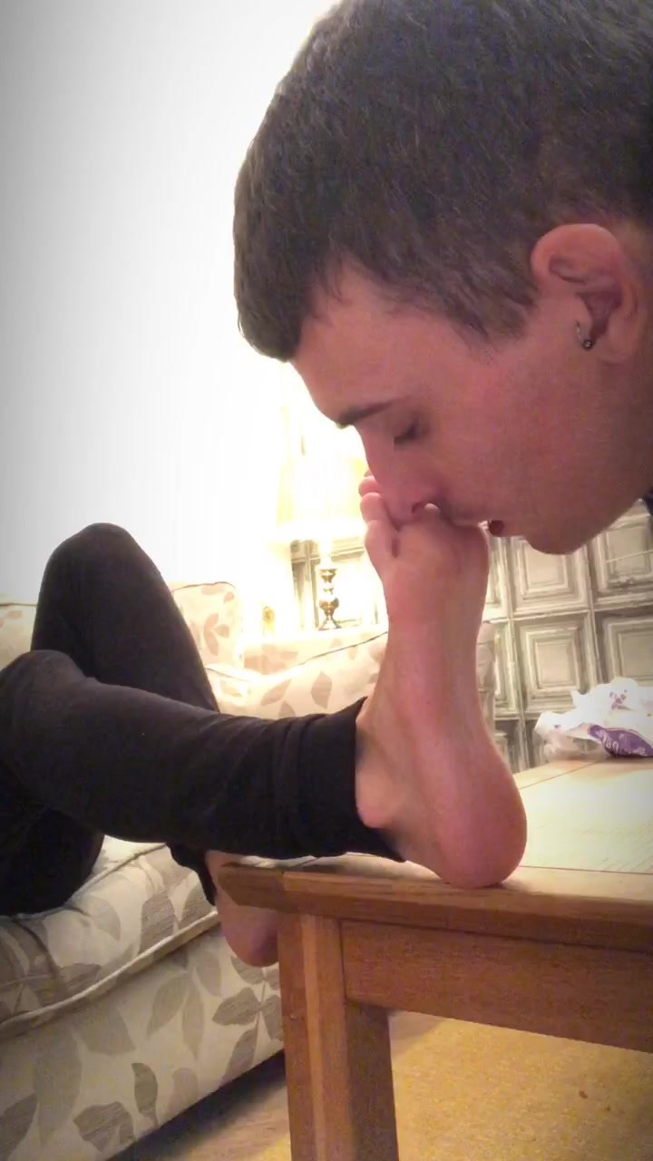 Cute slave sniffs and licks his masters feet