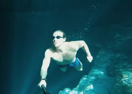 Muscled freediver breatholds underwater