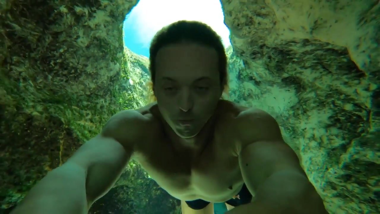 Muscled freediver breatholds barefaced underwater