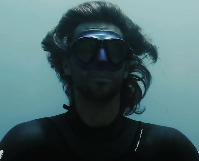 Guillaume breatholds underwater in tight wetsuit