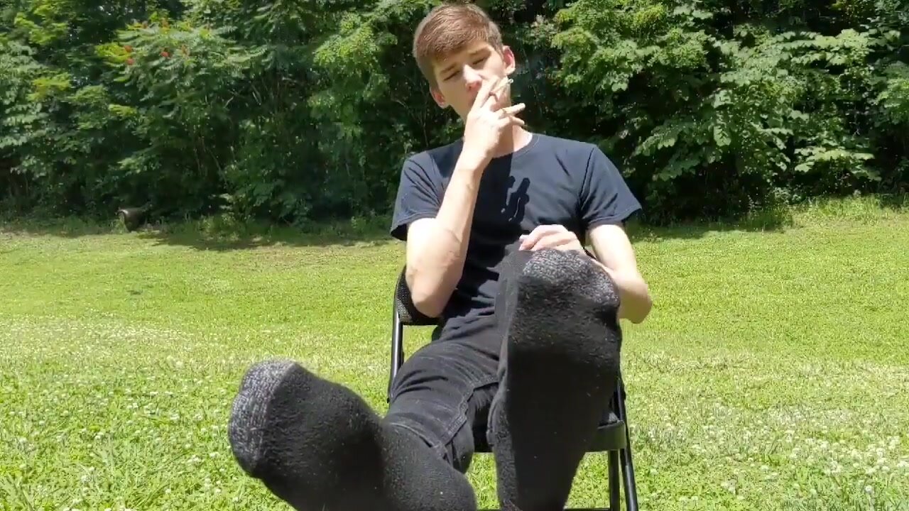 boy smokes and shows feet and sneakers