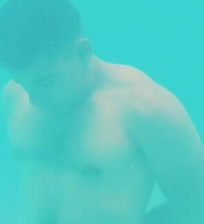 Muscled guy barefaced underwater