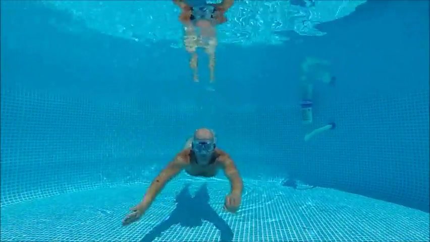 Bald guy swimming naked underwater