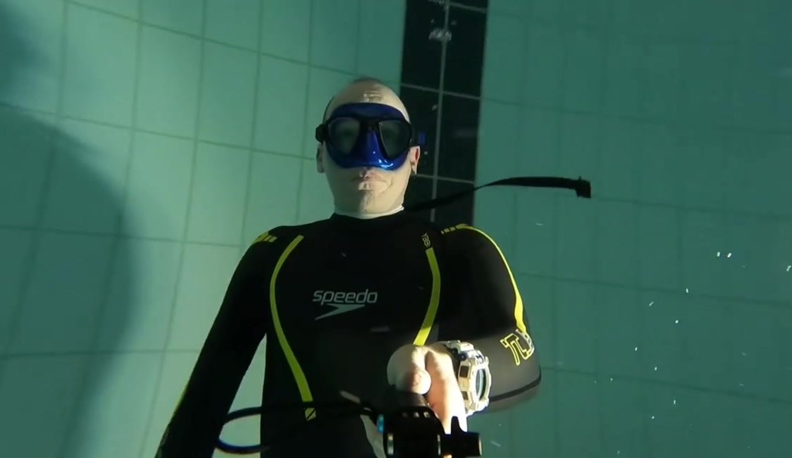 Hot wetsuited freediver breatholding underwater