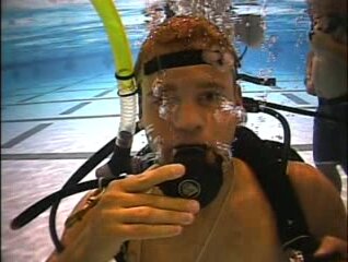 Barefaced scubadiver exhaling air underwater